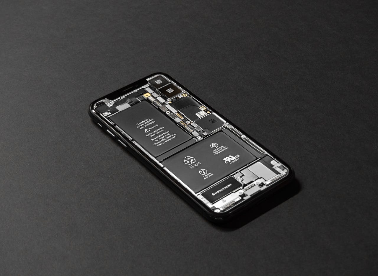 Services-03 High-resolution image of a smartphone showcasing its internal components on a dark surface.